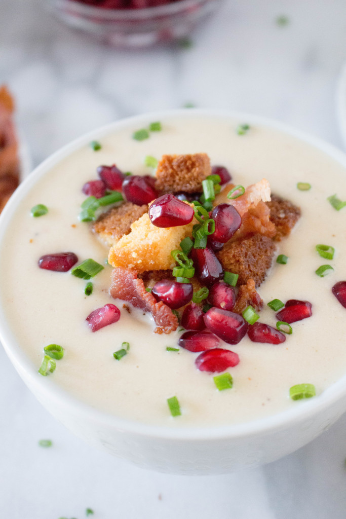Creamy Parsnip Soup with Cornbread Croutons, Crispy Bacon, & Pomegranate Arils! It's perfect for serving buffet style at a holiday party! It's all about those toppings! | yestoyolks.com